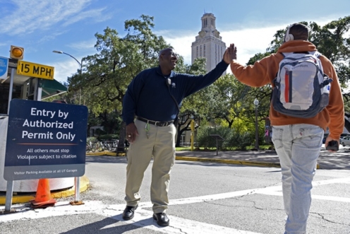 A safety expert high-fives a student at an intersection.