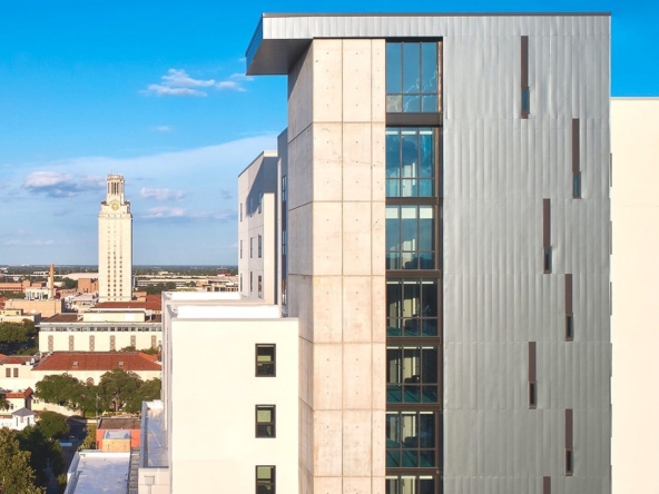 Aerial view of the side of the Skyloft apartment building with the UT Austin Tower in the background