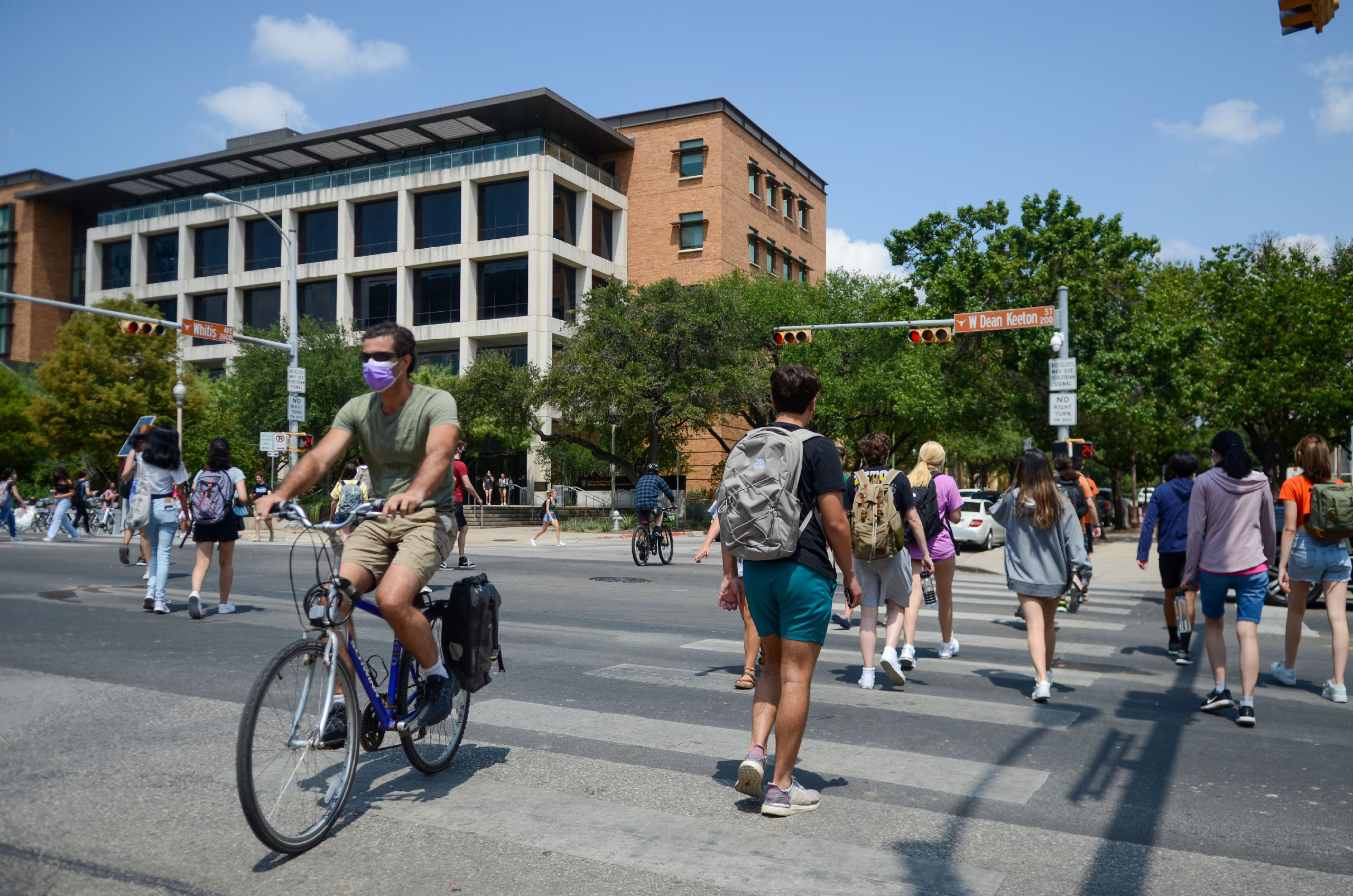People cross the street at the UT-Austin campus