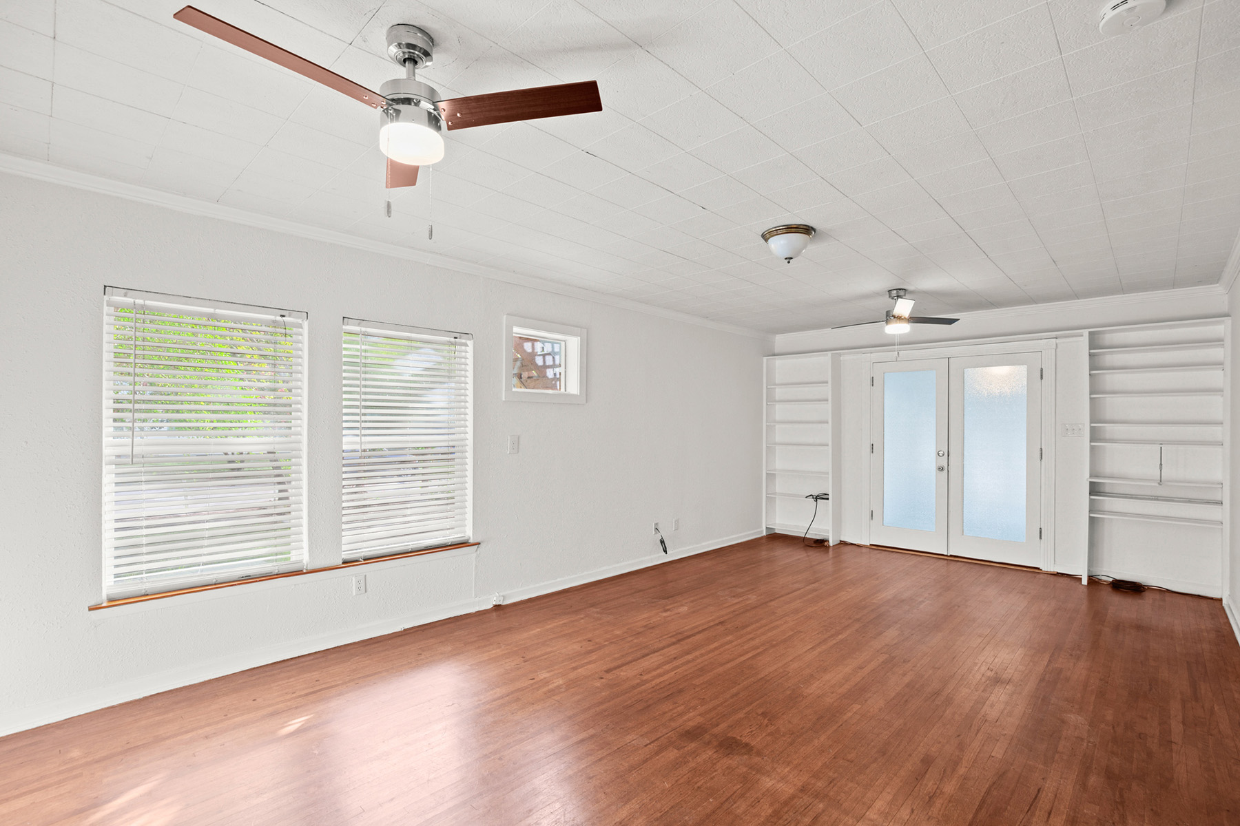 Room with windows, ceiling fans and French doors